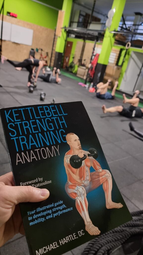 Photo of KBSA book cover in gym with kettlebells.